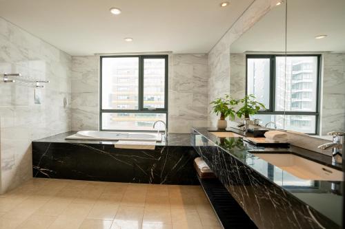 a bathroom with a black counter and a sink at My Way Hotel & Residence Ha Noi in Hanoi