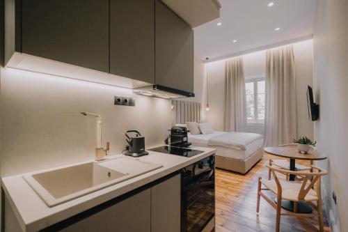 une cuisine avec un évier et une cuisine avec un lit dans l'établissement SanRocco Suites by Corfu Collection, à Ágios Rókkos