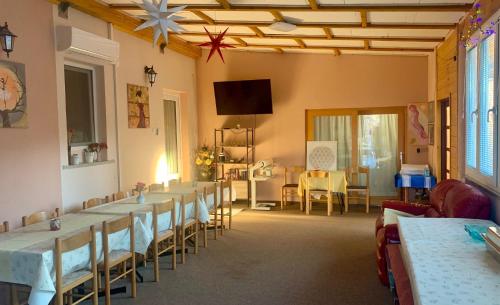 a dining room with tables and chairs and a television at TURIZEM GRABRIJAN, Jasmina Grabrijan s.p. in Adlešiči