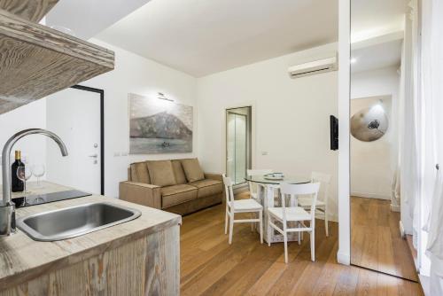 cocina y sala de estar con sofá y mesa en Ferrini Home - Suites, en Catania