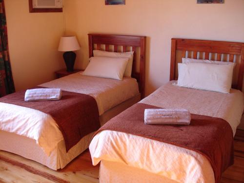 two beds sitting next to each other in a room at Reefteach Lodge in Sodwana Bay