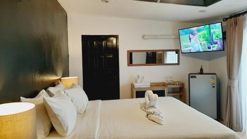 a bedroom with a bed with a tv on the wall at Big Boys' Bed & Burger in Patong Beach