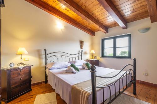 カルロフォルテにあるVilla Spalmatoreの木製の天井が特徴のベッドルーム1室(ベッド1台付)