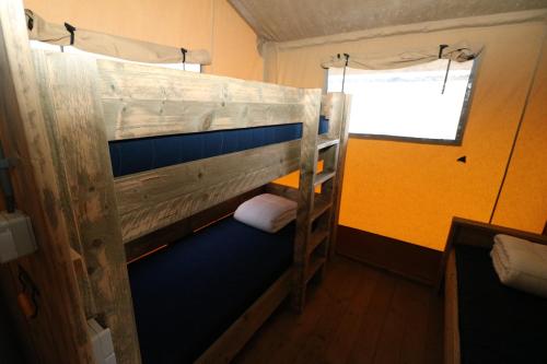 een stapelbed in een kamer met een raam bij De Zuidvliet Glamping Deluxe 1 in Wolphaartsdijk