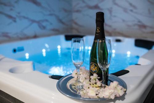 una bottiglia di champagne e due bicchieri su un tavolo in una vasca da bagno di Klečka vila B&B rooms a Ogulin