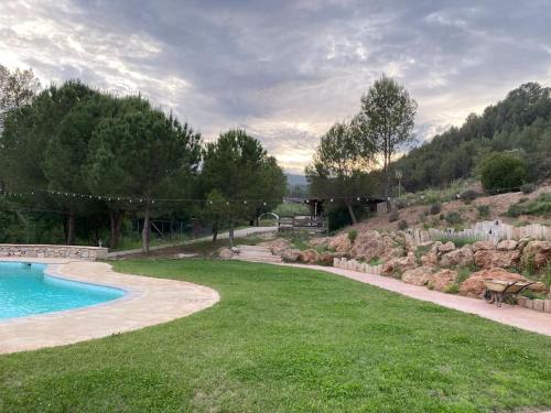 a backyard with a swimming pool and a grassy yard at Cal Masses , St. Salvador de Guardiola in Guardiola