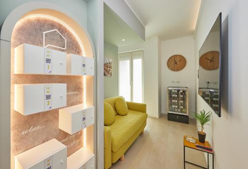 a living room with a yellow couch and a clock at Gioia 55 in Milan