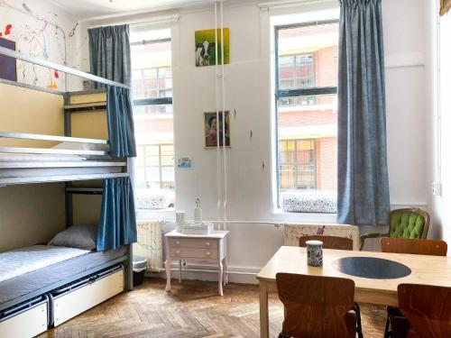 a bedroom with a bunk bed and a table and chairs at Hostel ROOM Rotterdam in Rotterdam
