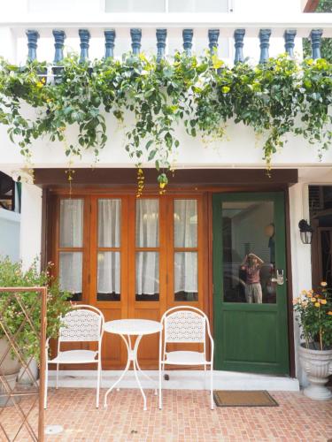 a patio with two chairs and a table in front of a door at Cozy House in Middle of Old Town Chiangmai in Chiang Mai