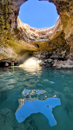 a cave with water and a person in the water at Casale del Forno in Andrano