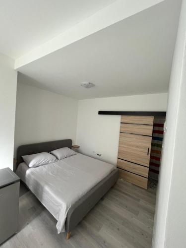 a bedroom with a white bed and a wooden floor at Ada in Zadar
