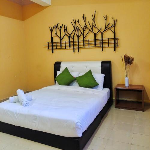 a bedroom with a white bed with green pillows at Rhu Dormitory in Tanjung Rhu 
