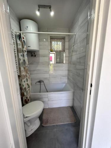 a bathroom with a tub and a toilet and a sink at Apartament in Orzysz