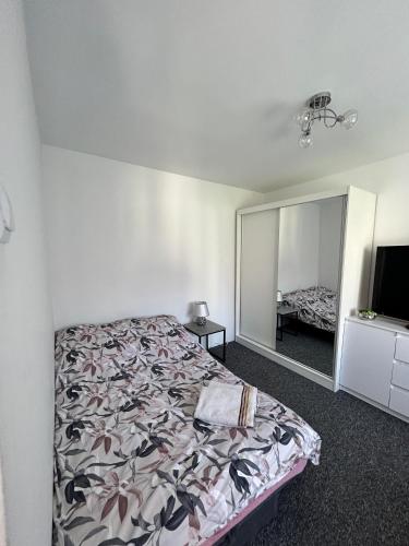 a bedroom with a bed and a large mirror at Apartament in Orzysz