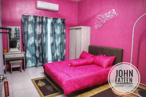 um quarto cor-de-rosa com uma cama com almofadas cor-de-rosa em lumut manjung homestay john faten em Lumut