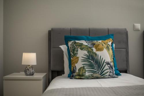 a bed with a blue and white pillow and a lamp at Anastasia Luxury House in Afantou