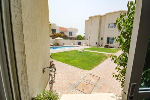 a bike parked next to a house with a pool at Comfortable Private Rooms in Compound Housing in Dubai