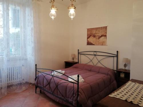 Schlafzimmer mit einem Bett mit einer roten Tagesdecke in der Unterkunft Casa di Pietro Aretino, Arezzo Centro Storico 4-8 letti in Arezzo