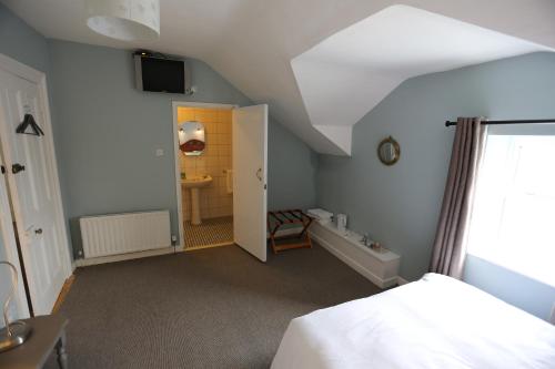 an attic room with a bed and a bathroom at Rolling Wave Guesthouse in Bundoran