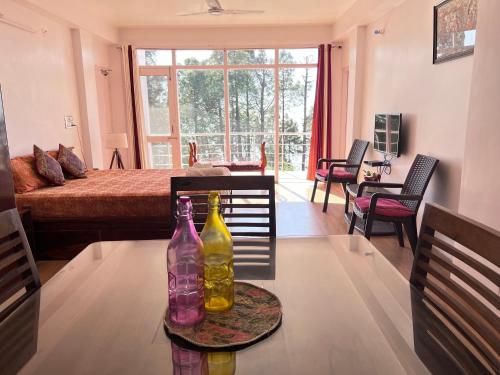 2 botellas sentadas en una mesa en una sala de estar en Satobari Greens Homestay, en McLeod Ganj