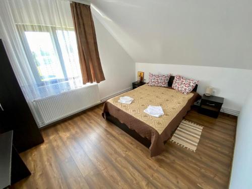 a small bedroom with a bed and a window at Pensiunea Agroturistica Matis in Râșca