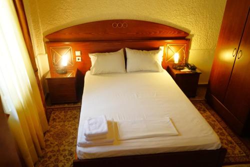 a bedroom with a large bed with two night stands at Chania Hotel in Chania