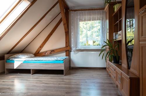 1 dormitorio con cama y ventana en Pokoje Upałty 21, en Giżycko
