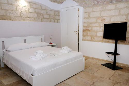 een witte slaapkamer met een bed en een flatscreen-tv bij Stairway to heaven in Bari