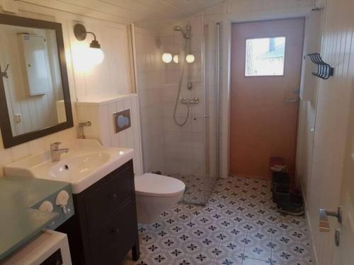 y baño con aseo, lavabo y ducha. en Charming beach house, en Moss