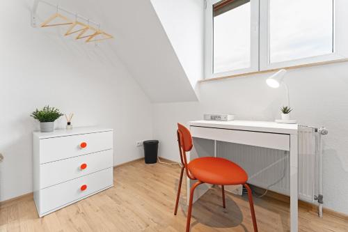 a white desk with a chair next to a white dresser at Helle moderne Wohnung, ,nahe Uni, zentral in Cottbus