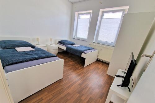 a bedroom with two beds and a television in it at Apartment with Roof-Top in Düren in Düren - Eifel