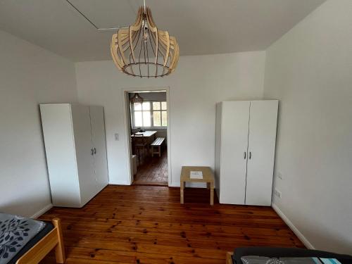 an empty room with two white cabinets and a chandelier at Große Monteurwohunung-Fewo in Trebbin