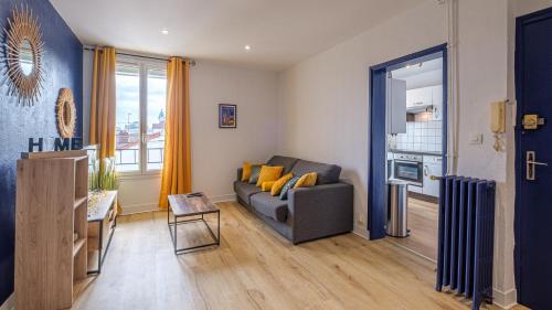 un salon avec un canapé et une fenêtre dans l'établissement Bleu Nuit - Welc'Home, à Limoges