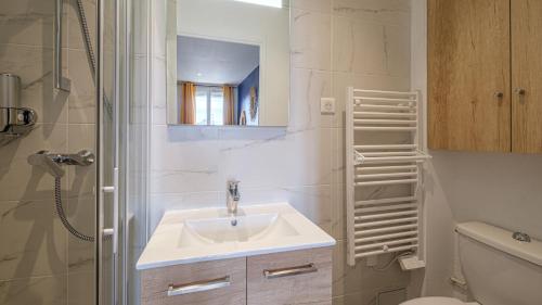 une salle de bain blanche avec un lavabo et une douche dans l'établissement Bleu Nuit - Welc'Home, à Limoges