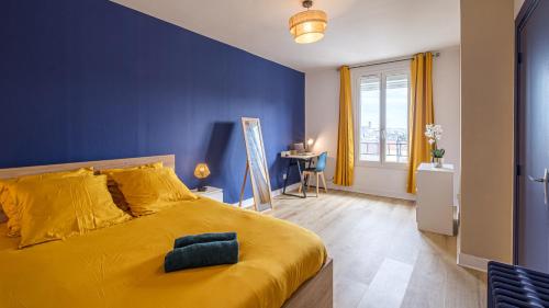 - une chambre avec un lit jaune et un mur bleu dans l'établissement Bleu Nuit - Welc'Home, à Limoges