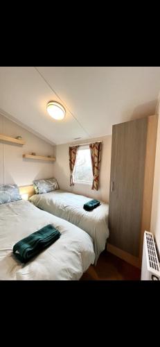 a room with three beds in it with a window at Tarka Holiday Park in Ashford