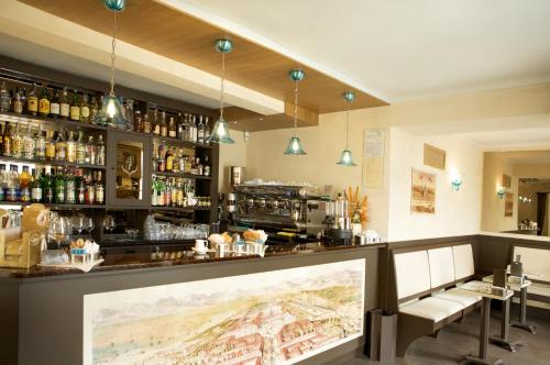 eine Bar in einem Restaurant mit einer Theke und Stühlen in der Unterkunft La Finestra Sulla Reggia in Venaria Reale