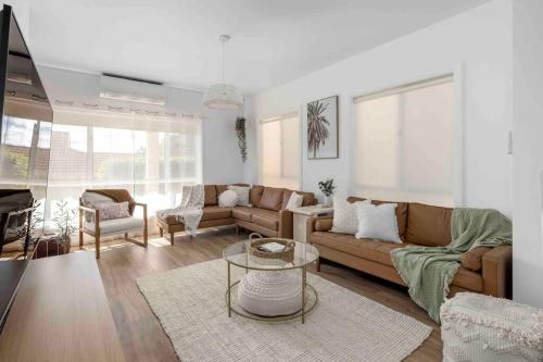 a living room with two couches and a table at Stylish family friendly oasis - Lette @ Corlette in Corlette