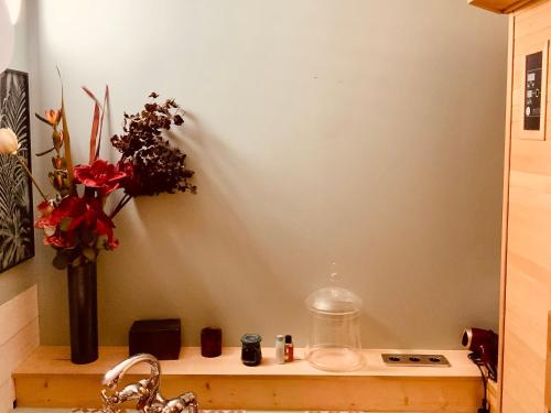 - un comptoir de cuisine avec un vase de fleurs et un évier dans l'établissement Belle chambre en rez de chaussée avec sauna dans quartier calme, à Bordeaux
