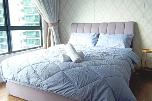 1 dormitorio con cama azul y ventana grande en Bukit Jalil City of Green Condominium 温馨小型舒服住所适合一家4口, en Seri Kembangan