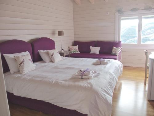 a bedroom with a large bed with a purple headboard at Ktima Noosfera Wellness & Retreat Center in Nees Vrisoules