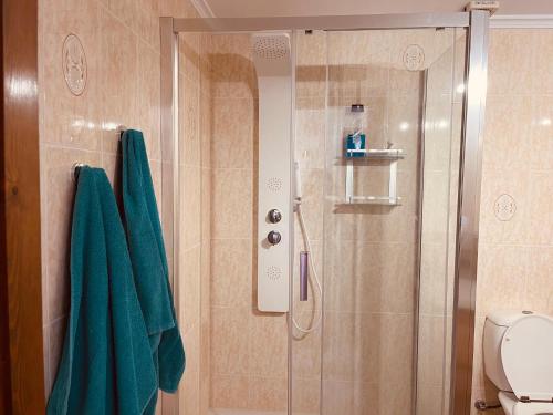uma casa de banho com um chuveiro e toalhas verdes em La Casa Leelouka em Moraira