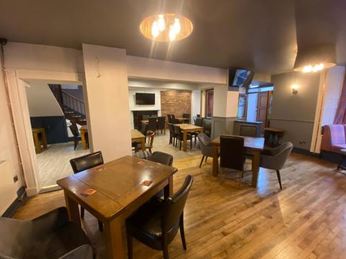 a room with tables and chairs and a dining room at Plas Coch Hotel Ltd in Bala
