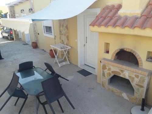 a patio with a fireplace and a table and chairs at Montemar Studios & Apartments in Arkasa