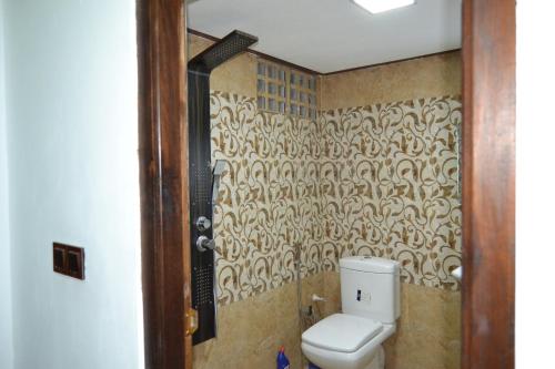 a bathroom with a toilet and a wall at BW Residence in Kalmunai