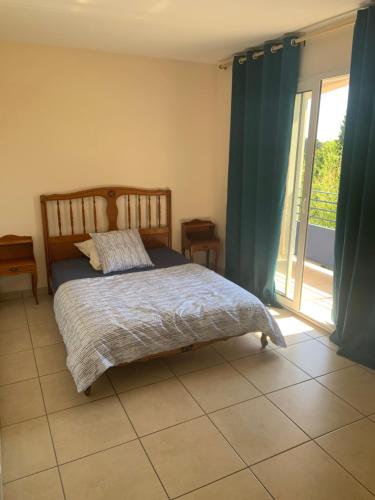 una camera con un letto e una grande finestra di klm a Roussillon en Isere