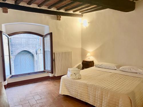 1 dormitorio con cama y ventana grande en Franciosa Lodge - Cattedrale, en Siena
