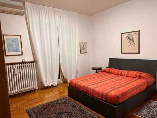 um quarto com uma cama com um cobertor vermelho em A casa di Gianni em Gallarate