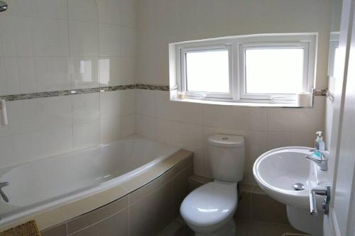 a bathroom with a tub and a toilet and a sink at Still Waters in Coleraine