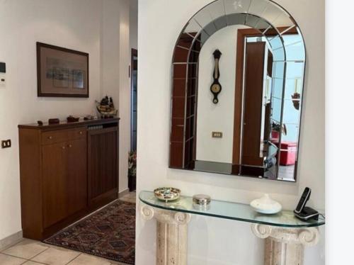 uma casa de banho com um balcão e um espelho na parede em A casa di Gianni em Gallarate